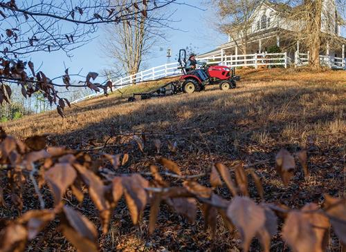 man driving across lawn on red yanmar sa 324