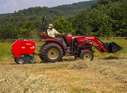 large red baler with hay