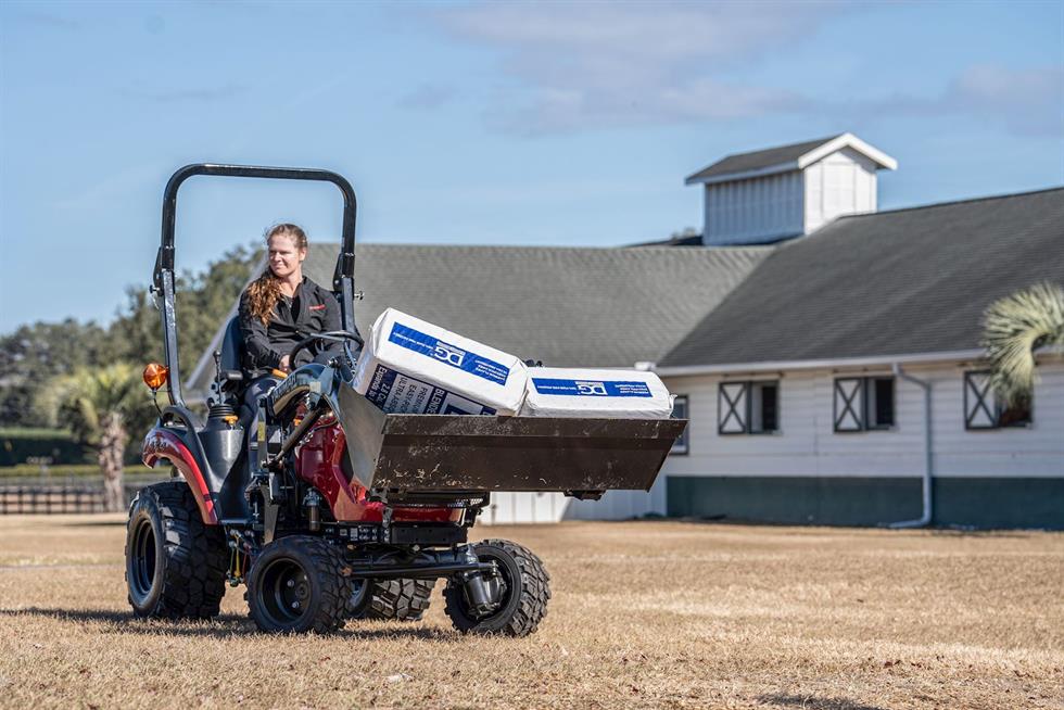 Woman driving SA223 KURO with feed in the loader bucket