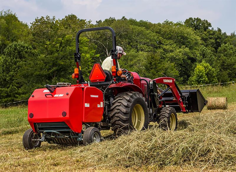 large red baler with hay