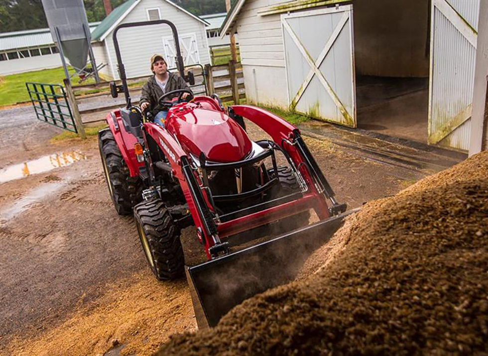 red yanmar tractor man digging